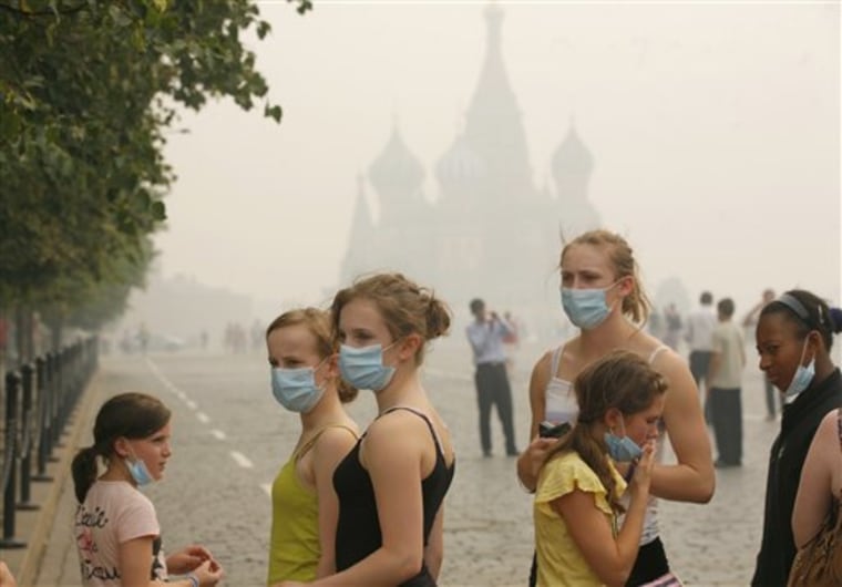 Young American tourists, no name or details given, brave the thick blanket of smog covering Moscow as they visit the Red Square on Sunday.